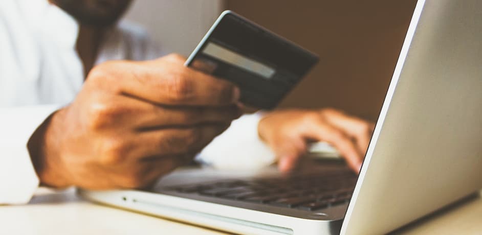 Zahlungsdienstleister Shopsysteme Buchhandlungen Eine Person mit Kreditkarte vorm Laptop